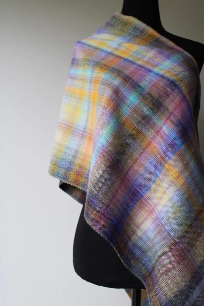 Cashmere wrap in heather shades with a tartan pattern.