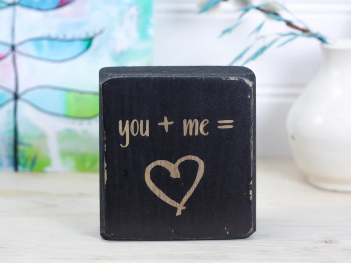 small wood sign that says you plus me equals love