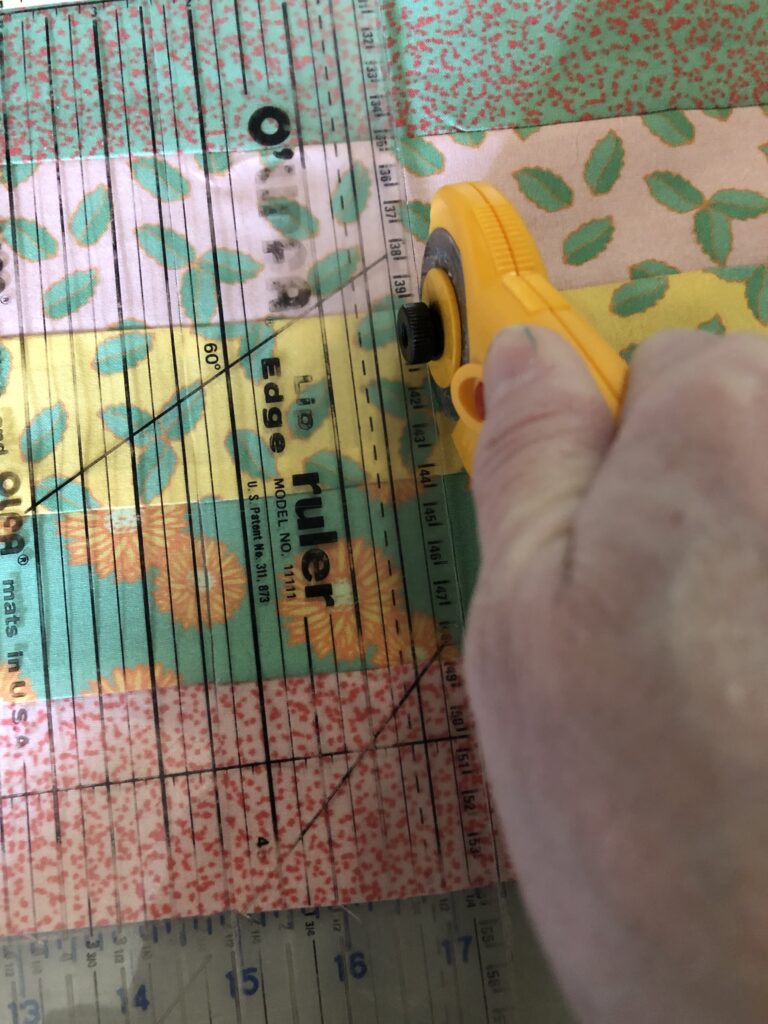 Cutting the sewn strip panels into thinner strips to make the checkerboard sections