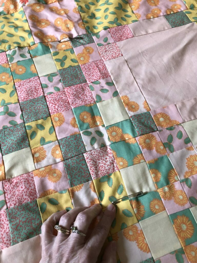 Pinning the three layers of the quilt together with safety pins