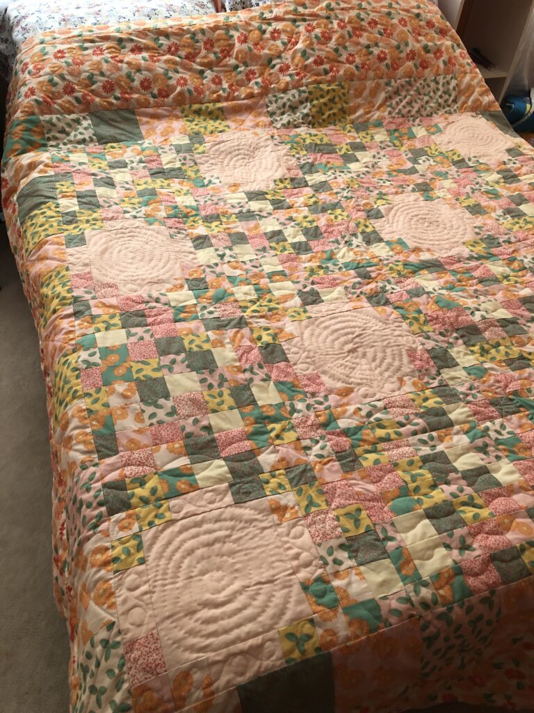 The finished quilt on a bed