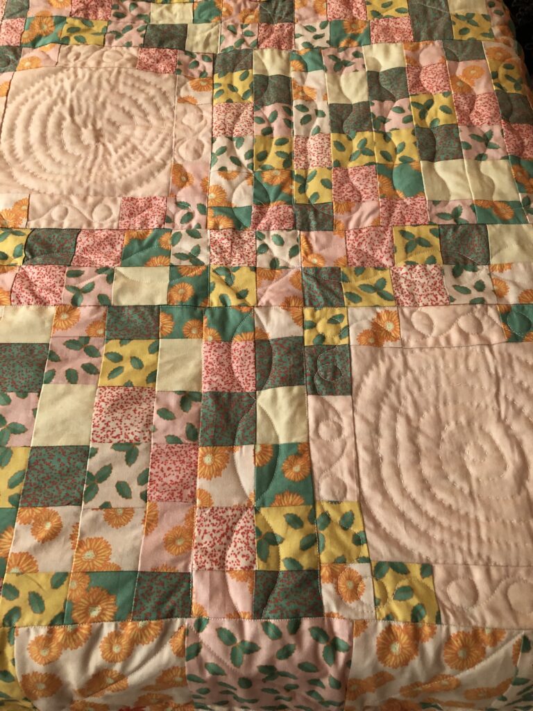 The finished quilt on a bed