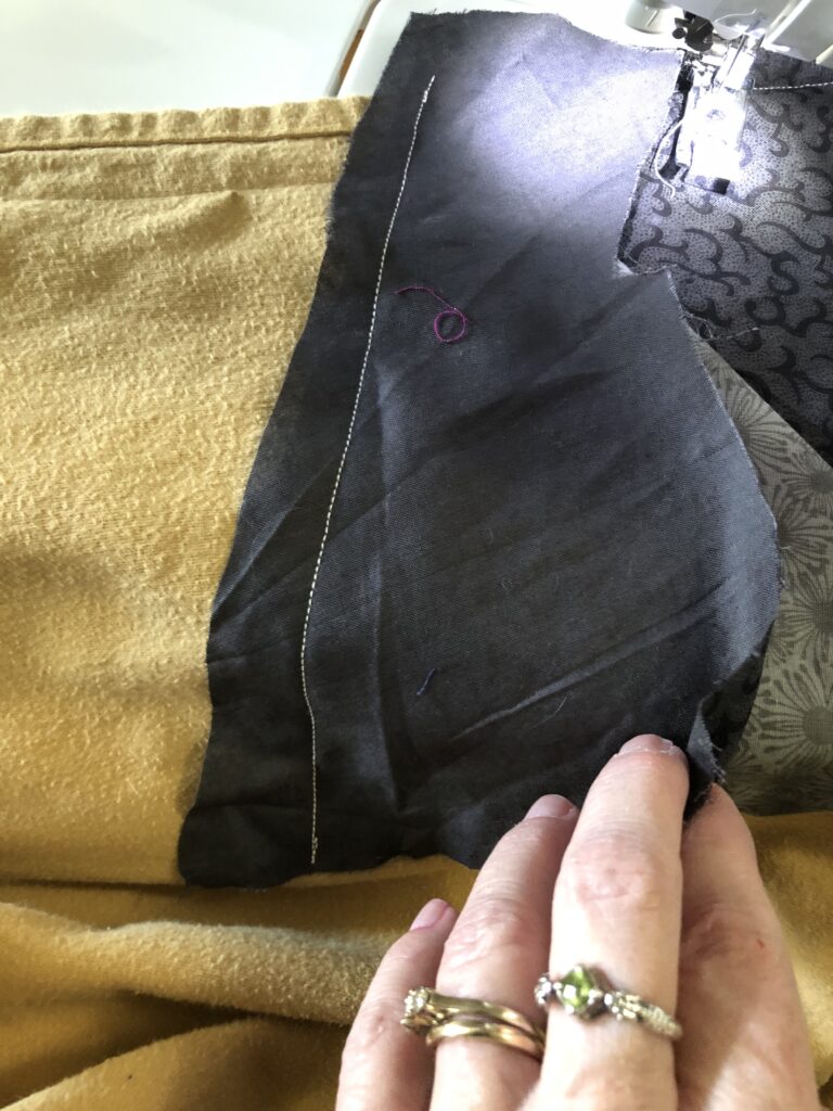 stitching a piece of fabric on the flannel sheet