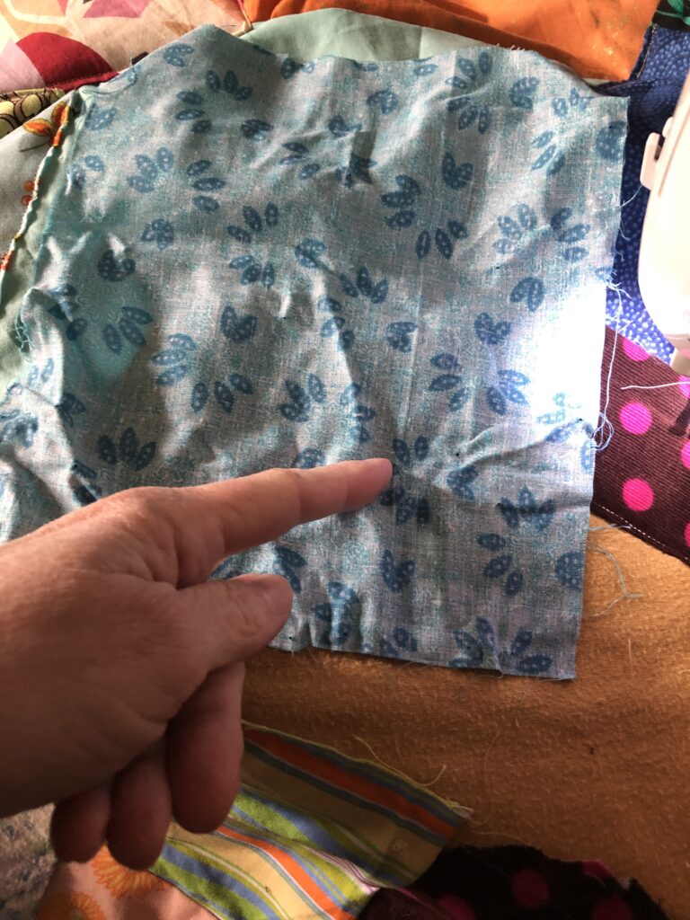 turning the fabric over to position it to be stitched to the quilt