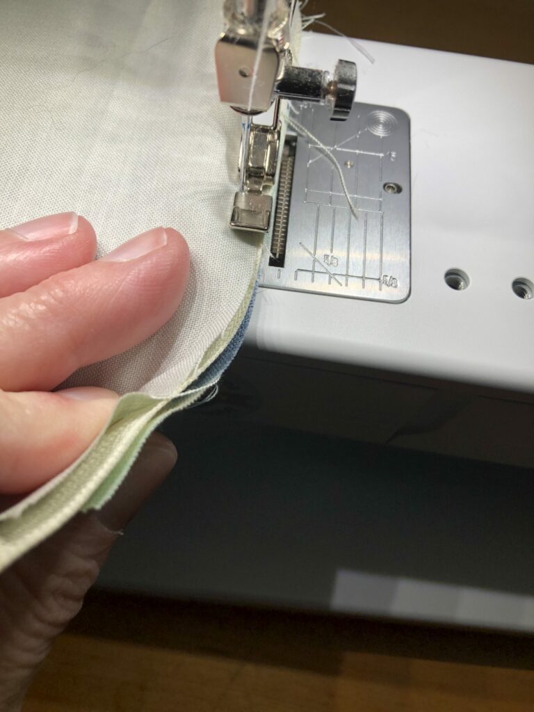 Sew through the lining, zipper, and main fabric alongthe curved edge