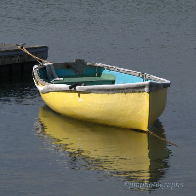 yellow rowboat tied to a dock
